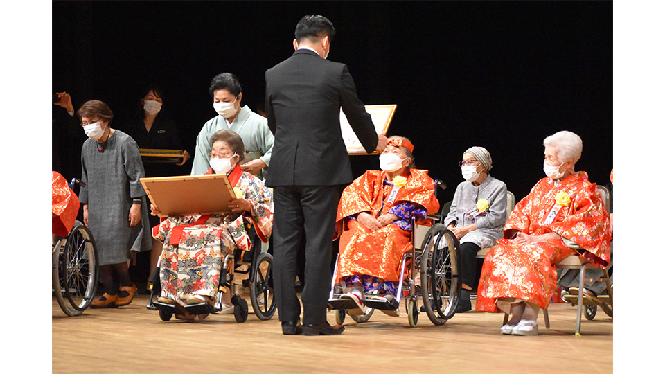 １０８歳の茶寿の皆さんに賞状を手渡す中山市長＝１２日、石垣市民会館大ホール