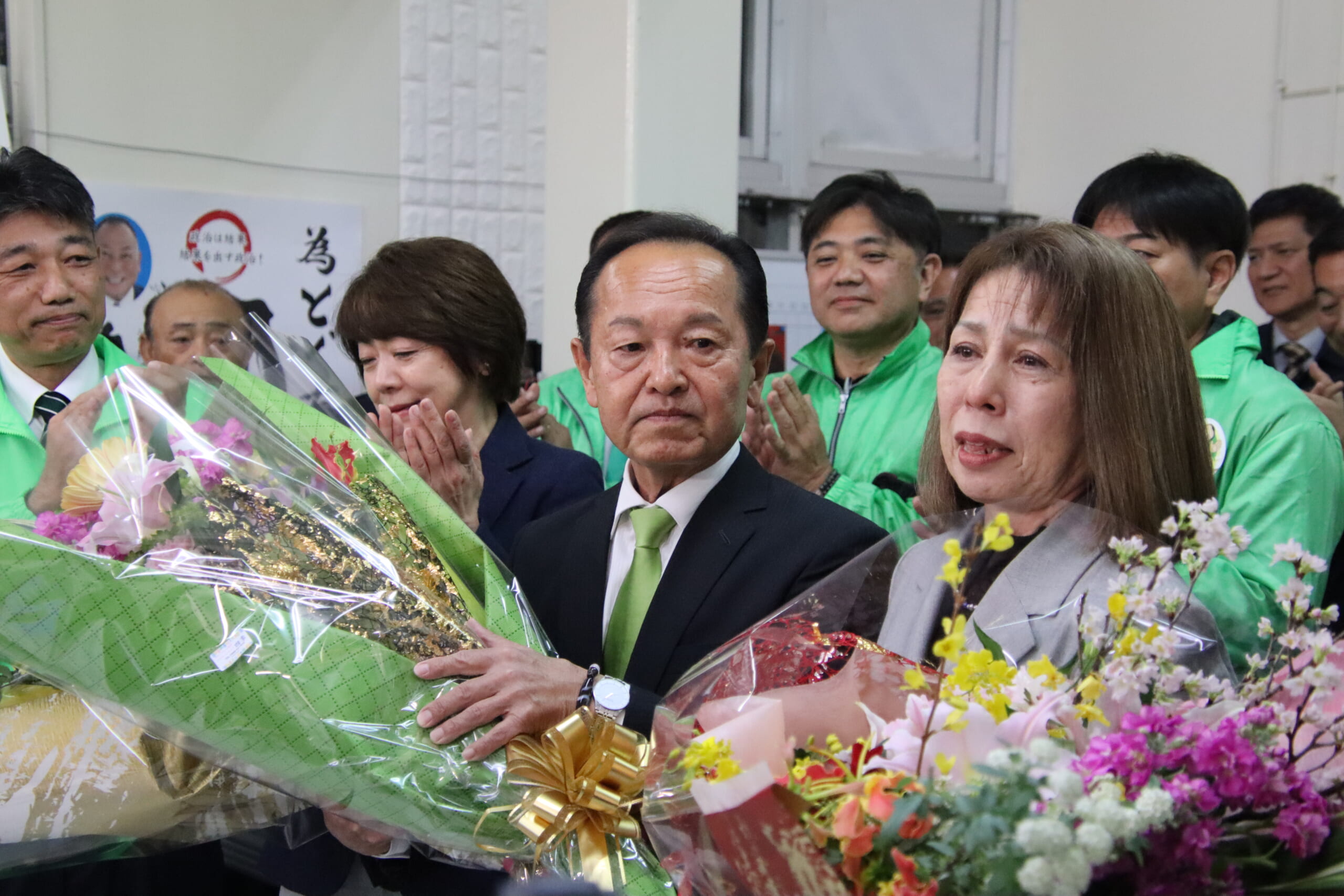 当選を確実にし、花束を受け取った渡具知氏＝25日夜、名護市